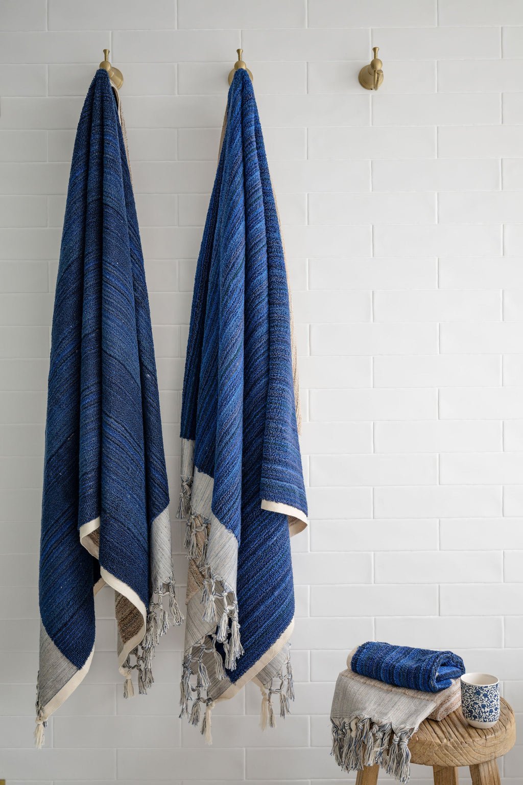 Large thick blue and ecru handwoven towel and small hand towel from Turkish Bath & Home, showcasing textured woven fabric.