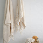 Turkish Bath & Home thick hand towels with ecru stripes, showcasing a luxurious, plush, medium-sized woven towel and matching hand towels.
