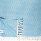 Light blue towel with white fringe and patterned design